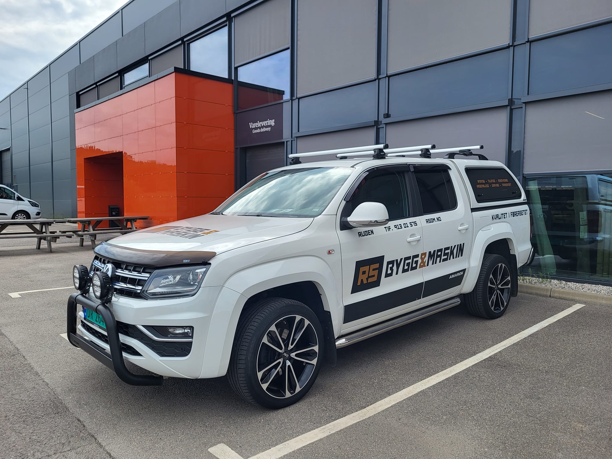 RS Bygg & Maskin firmabil parkert foran moderne bygg