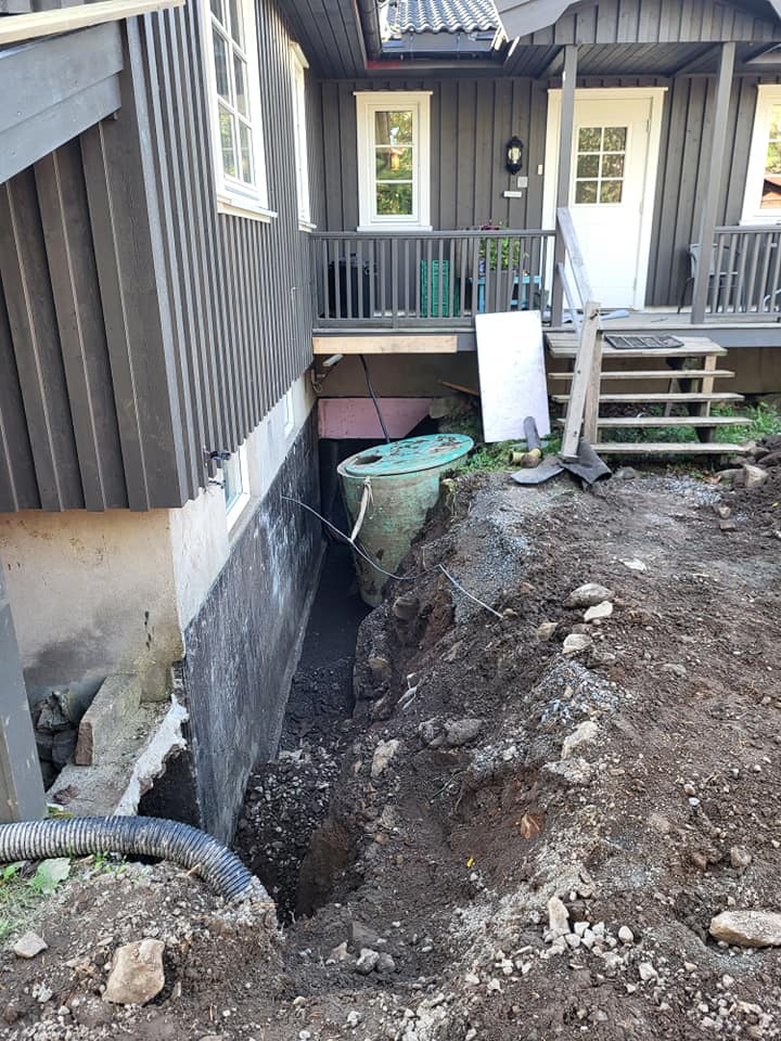 Dyp grøft for drenering ved siden av husets grunnmur