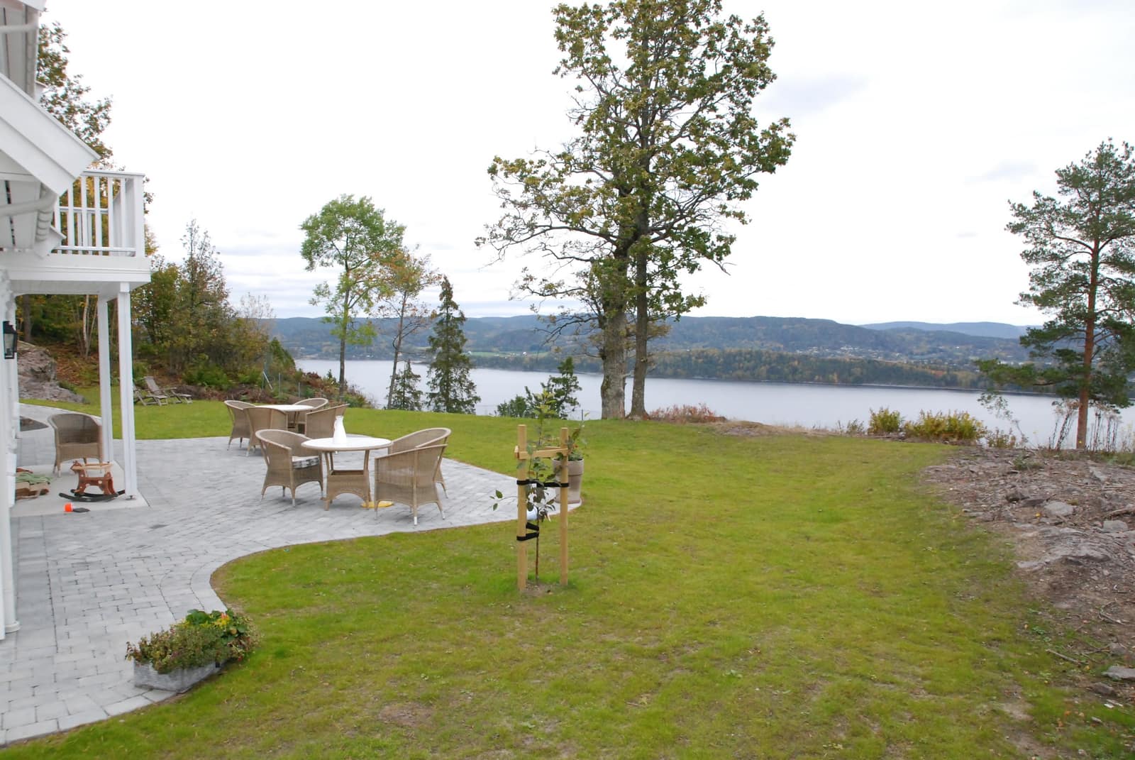 Plen og steinlagt uteplass med utsikt mot fjorden