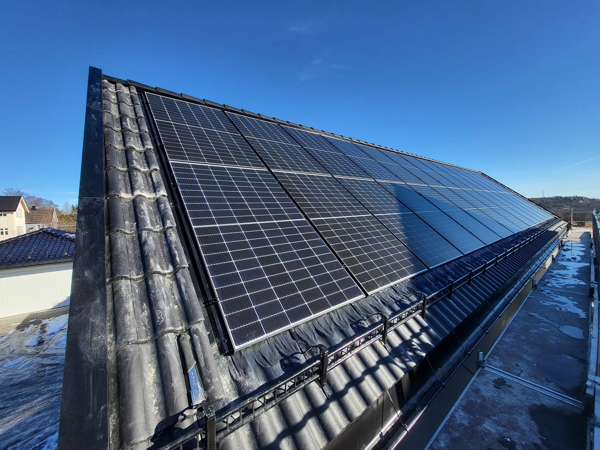 Ferdig installerte solcellepaneler på et mørkt tak