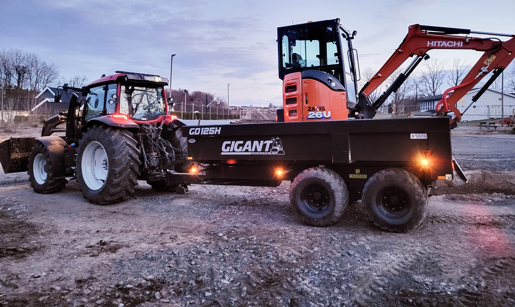Traktor med dumperhenger og minigraver lastet på, klar for transport